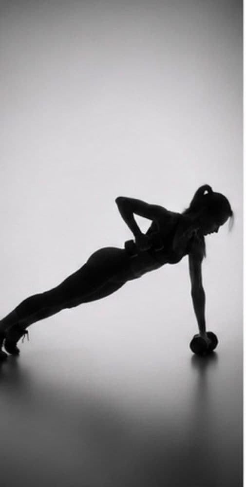 Silhouette d’une femme en appui sur un bras, un haltère au sol