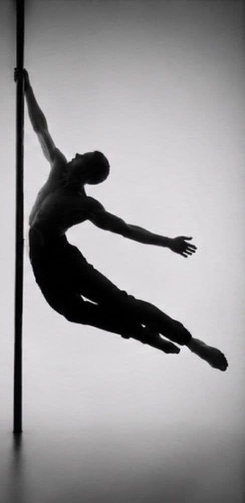 Silhouette d’un danseur suspendu à la barre, le corps en arc