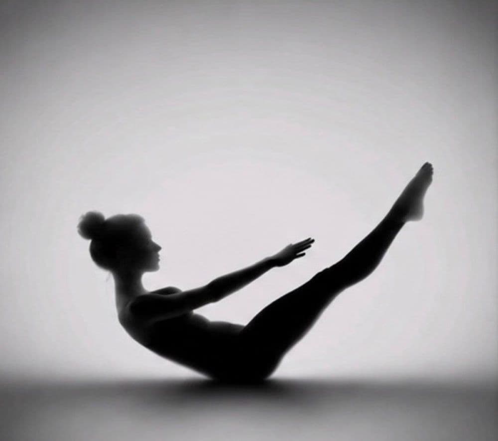 Silhouette d’une femme en équilibre, jambes et bras tendus