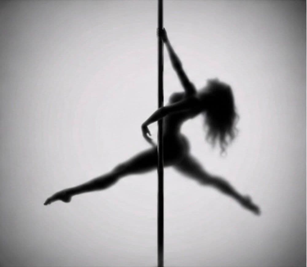 Silhouette d’une danseuse en écart, suspendue à la barre