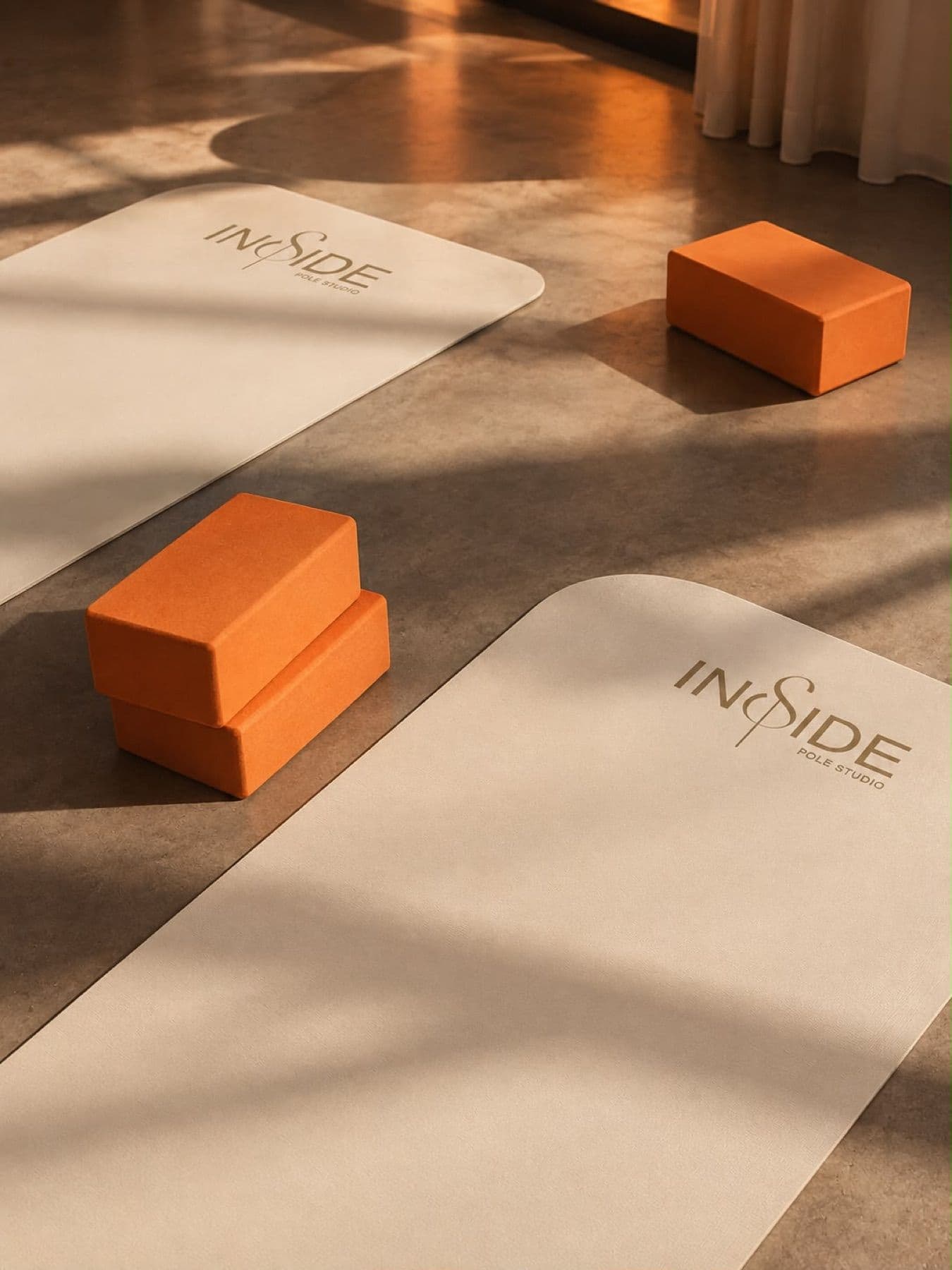 Projection du studio : deux tapis au logotype Inside et des blocs de mousse orange, dans la lumière du soir.